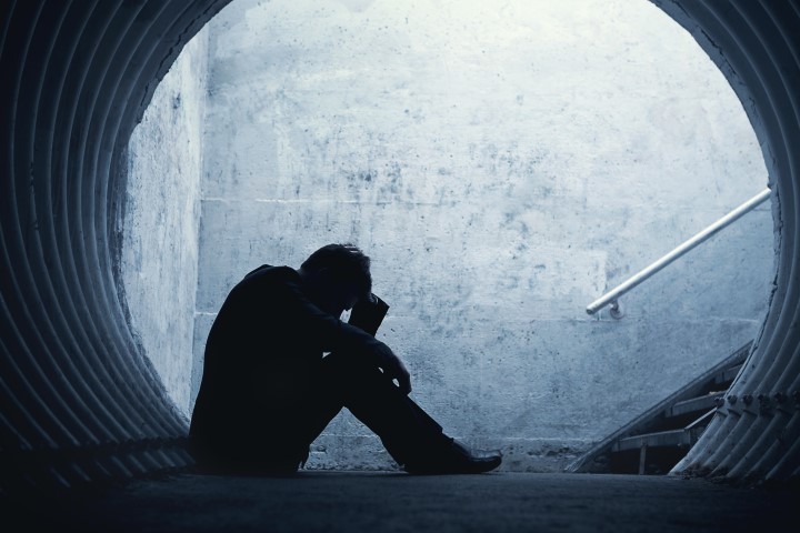 Desperate,Businessman,In,Silhouette,Lying,On,The,Ground,And,Holding